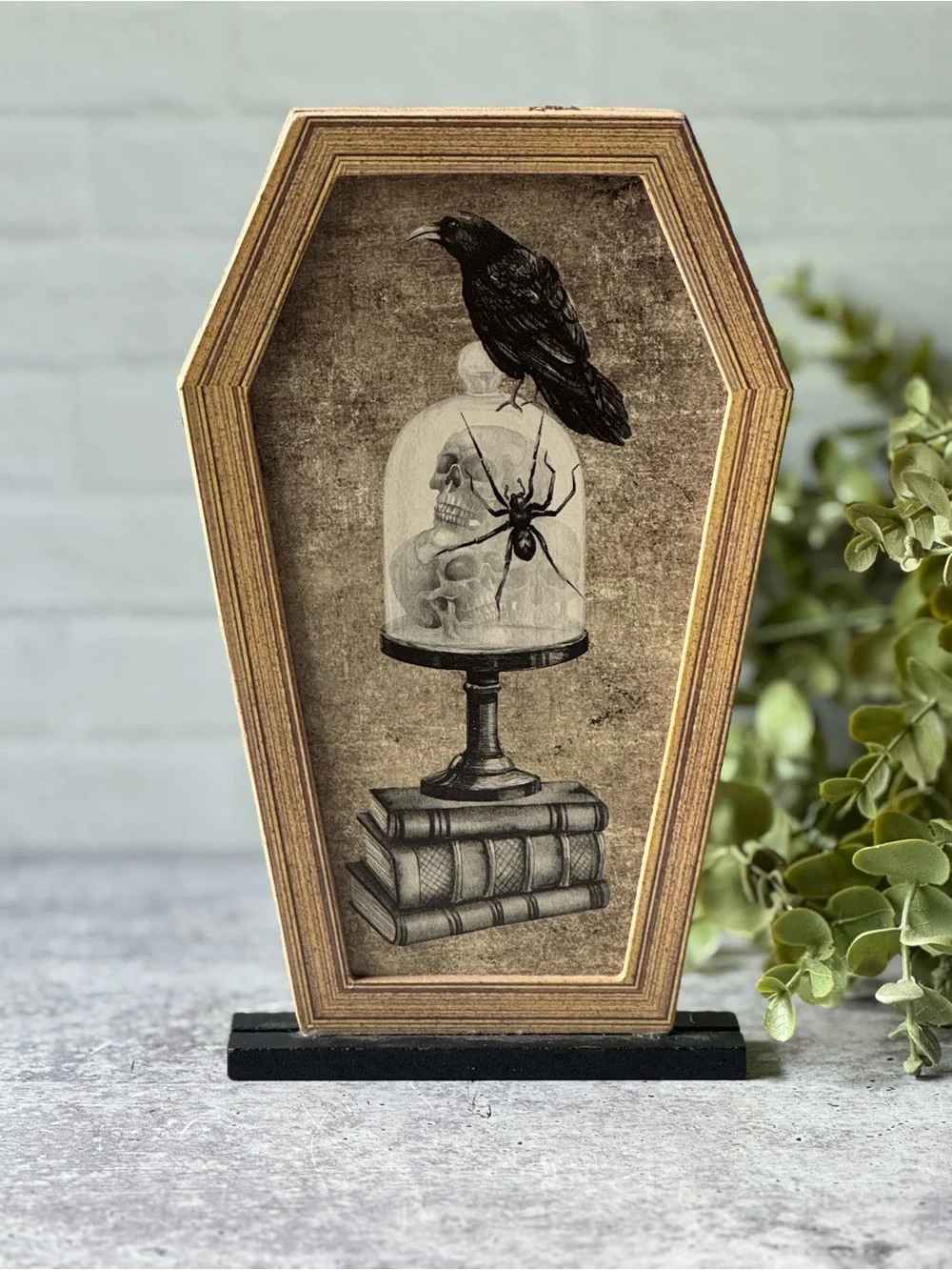 Coffin Shaped Halloween Decor with Crow, Skulls, Books, and Spider Illustration